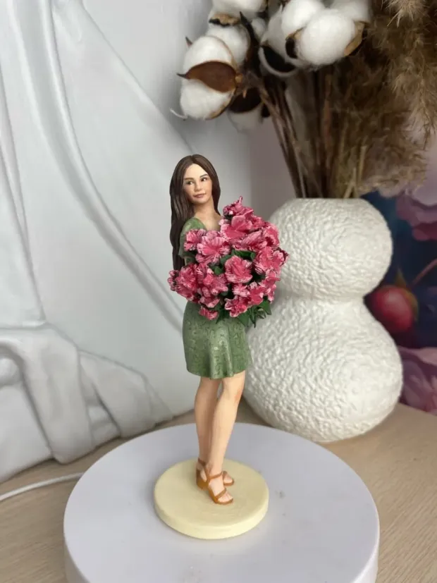 3D-фигурка девушки в зелёном платье с букетом розовых цветов